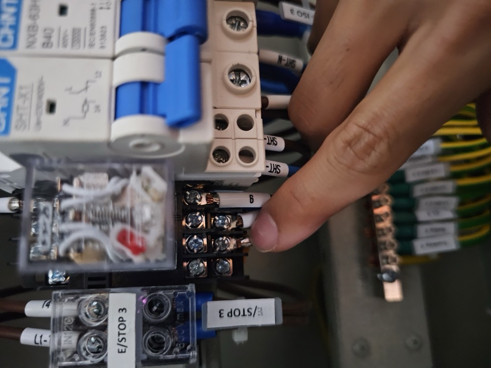 Close-up of a distribution board with a circuit breaker being worked on