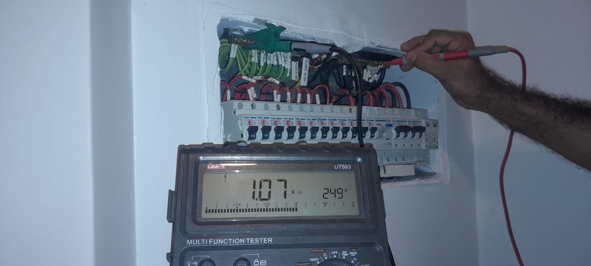 Electrician using a multifunction tester to check a circuit reading